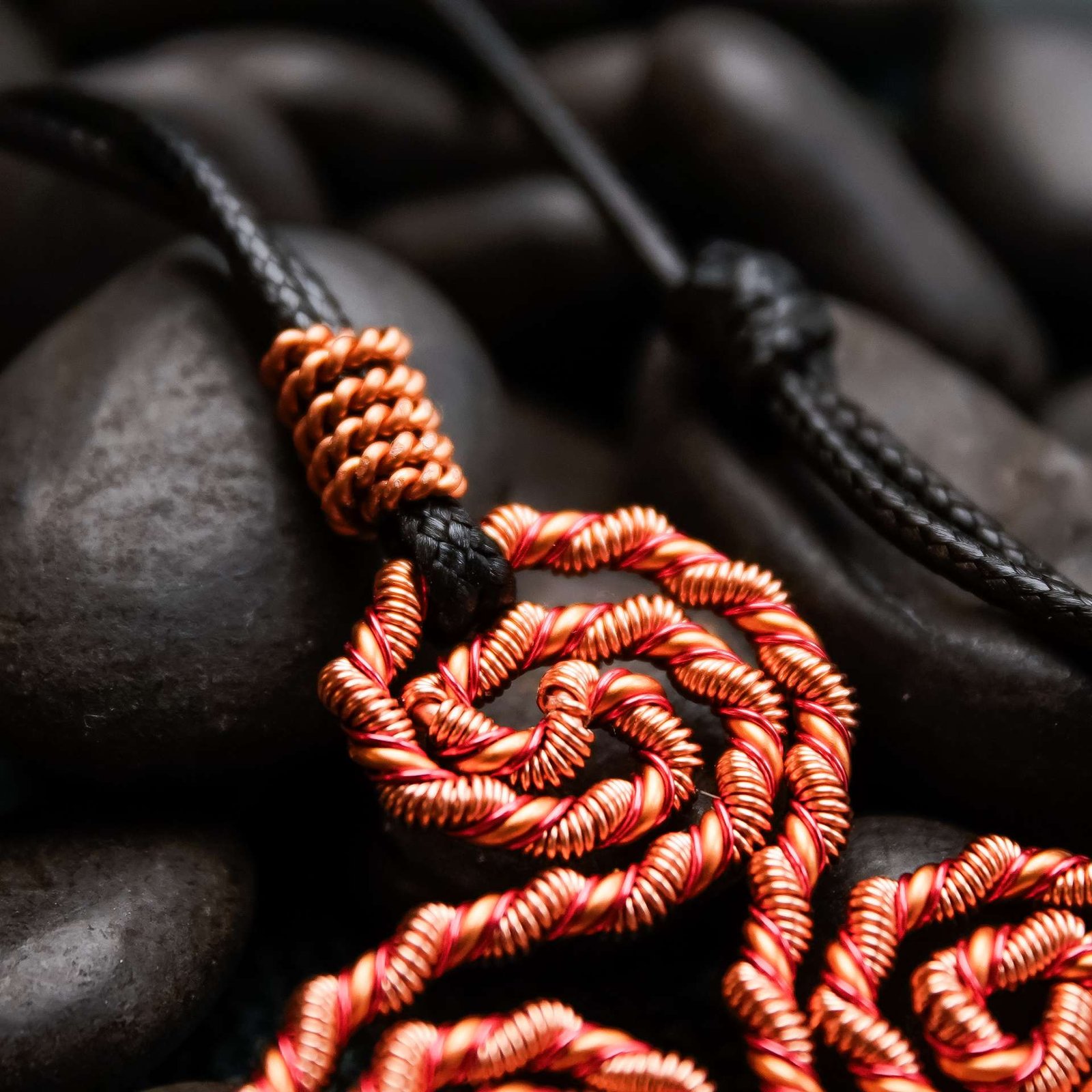Close-up of Flame copper coil showing red enamel wrap and sacred geometry detail