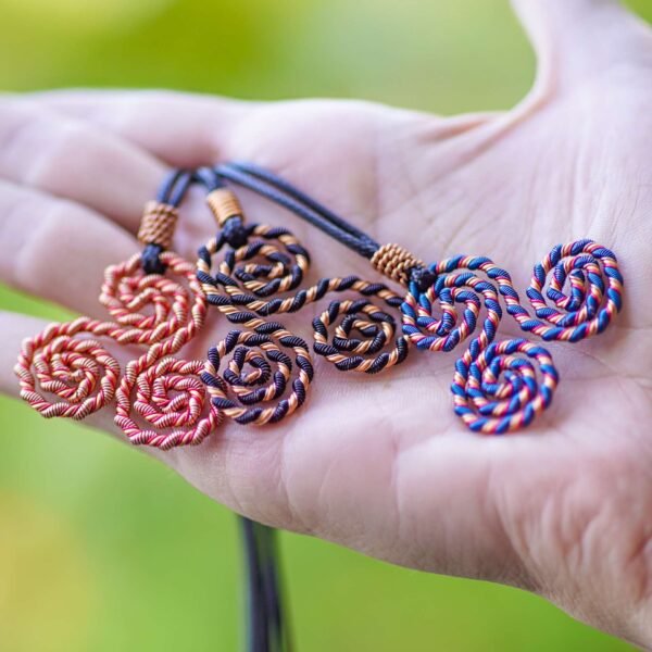 Triskelion energy necklace group image on hand